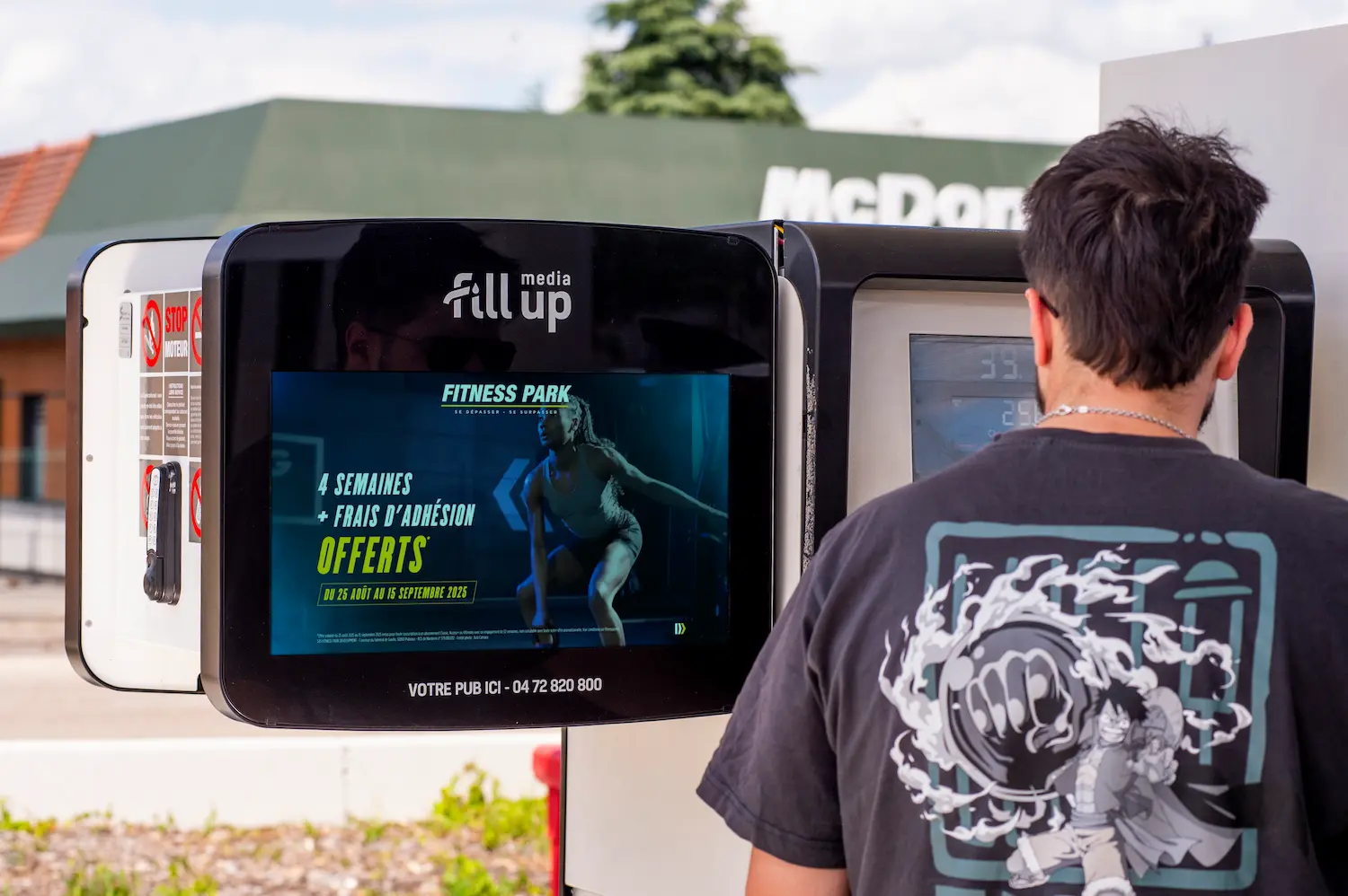Jeune homme qui regarde une publicité en station