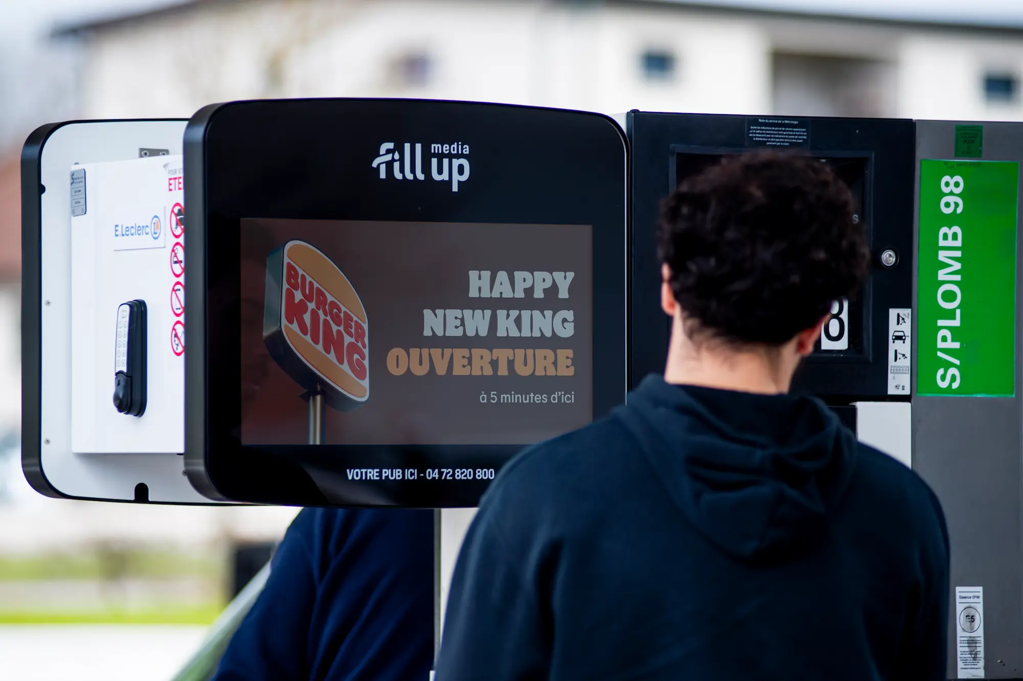 Un jeune homme regardant une pub burger king